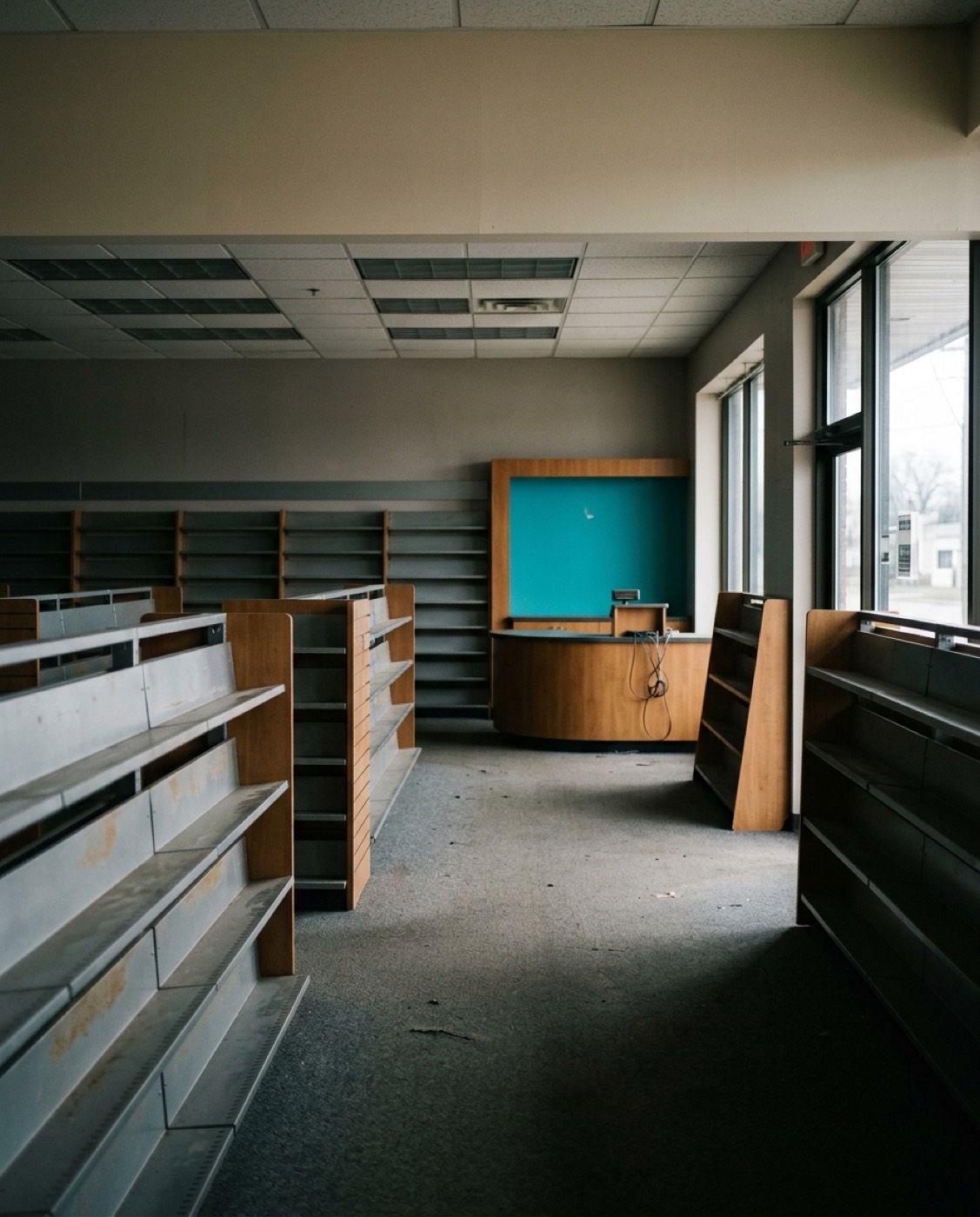 An empty video rental store: bare shelves, a counter with no one behind it
